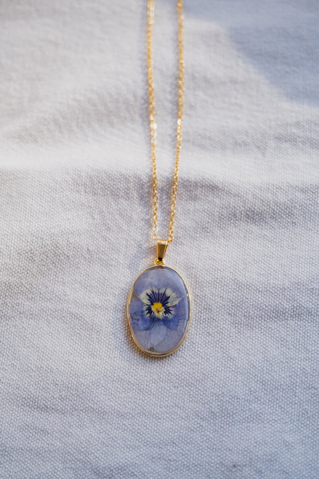 Collana ovale con viola del pensiero azzurra