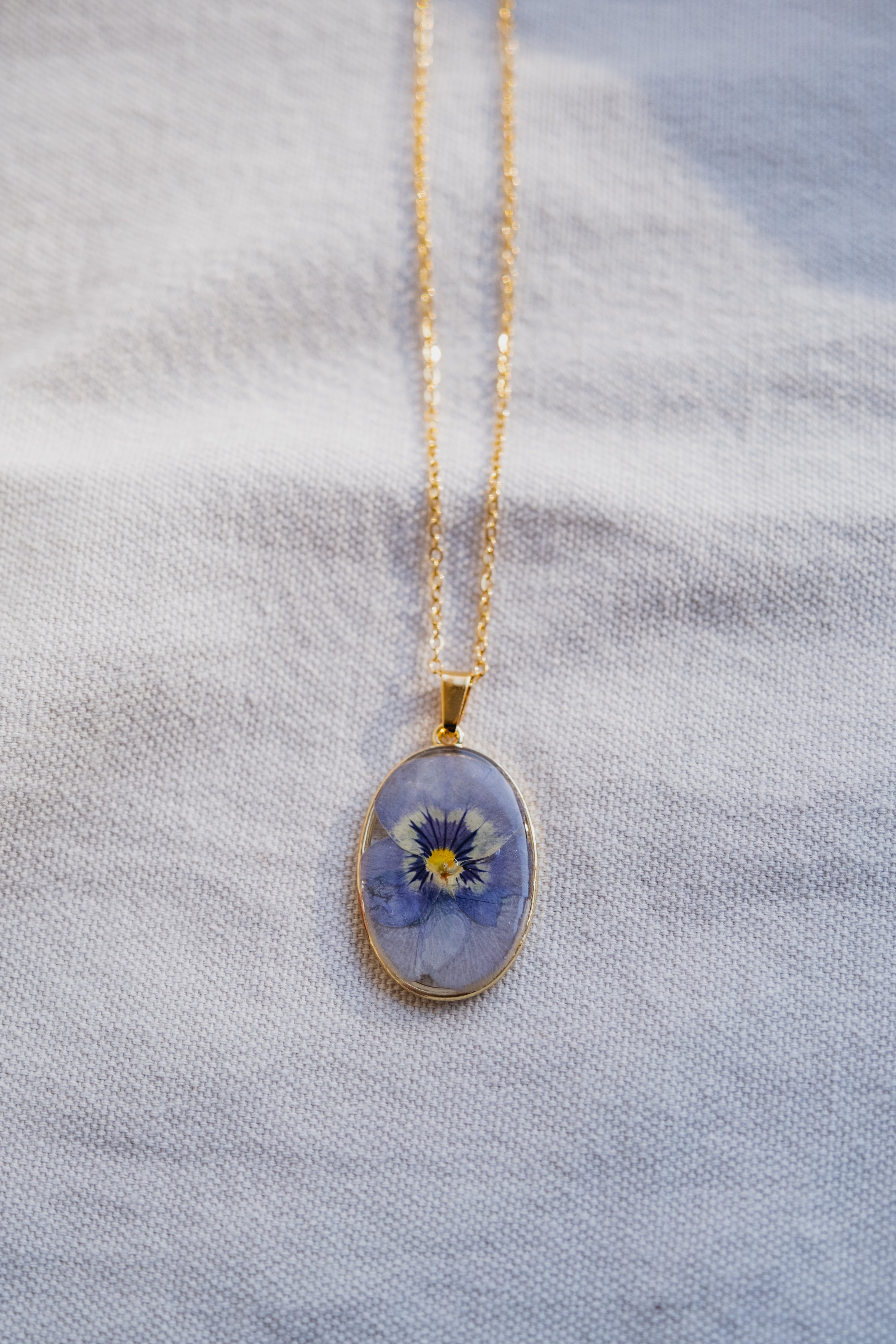 Collana ovale con viola del pensiero azzurra