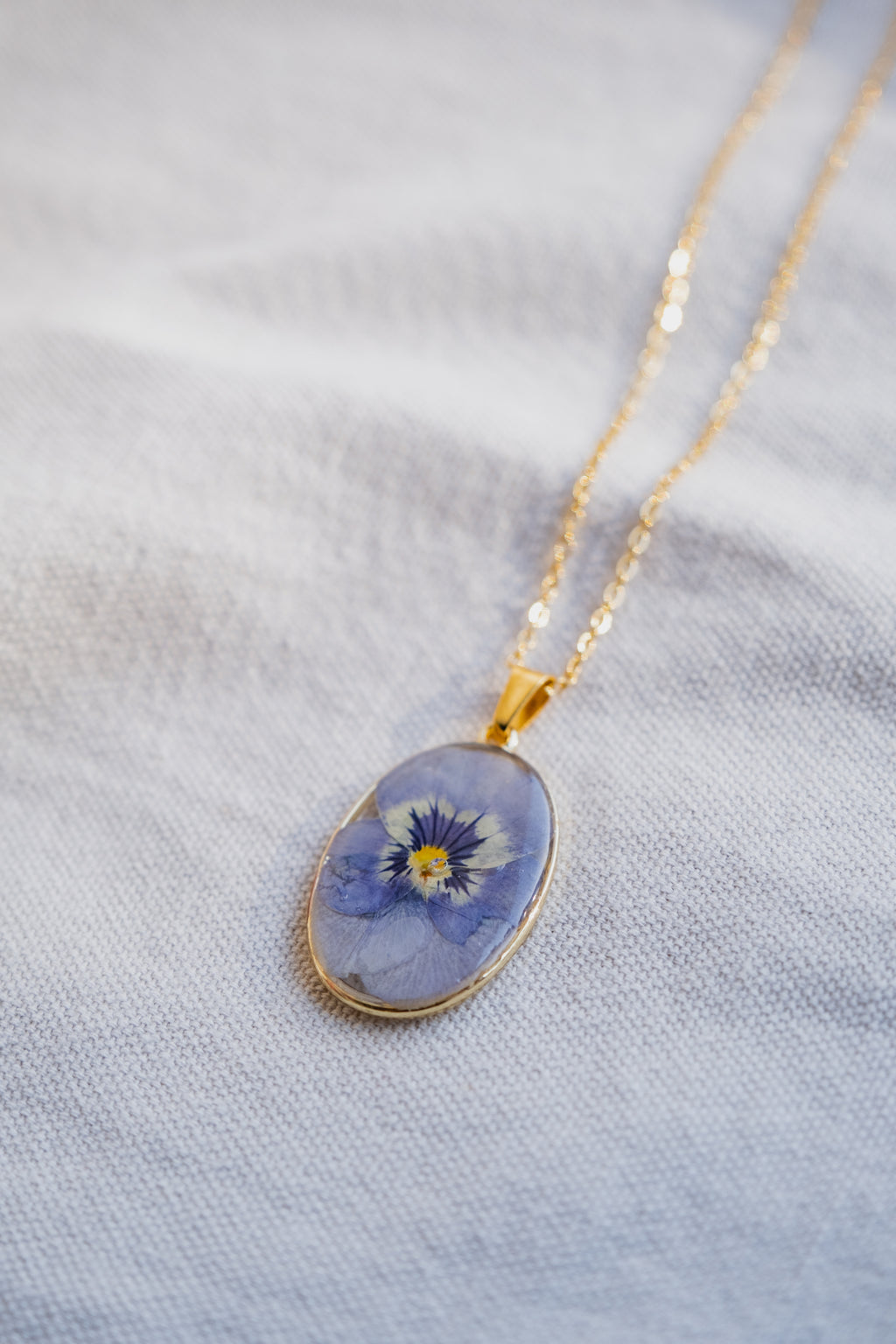 Collana ovale con viola del pensiero azzurra