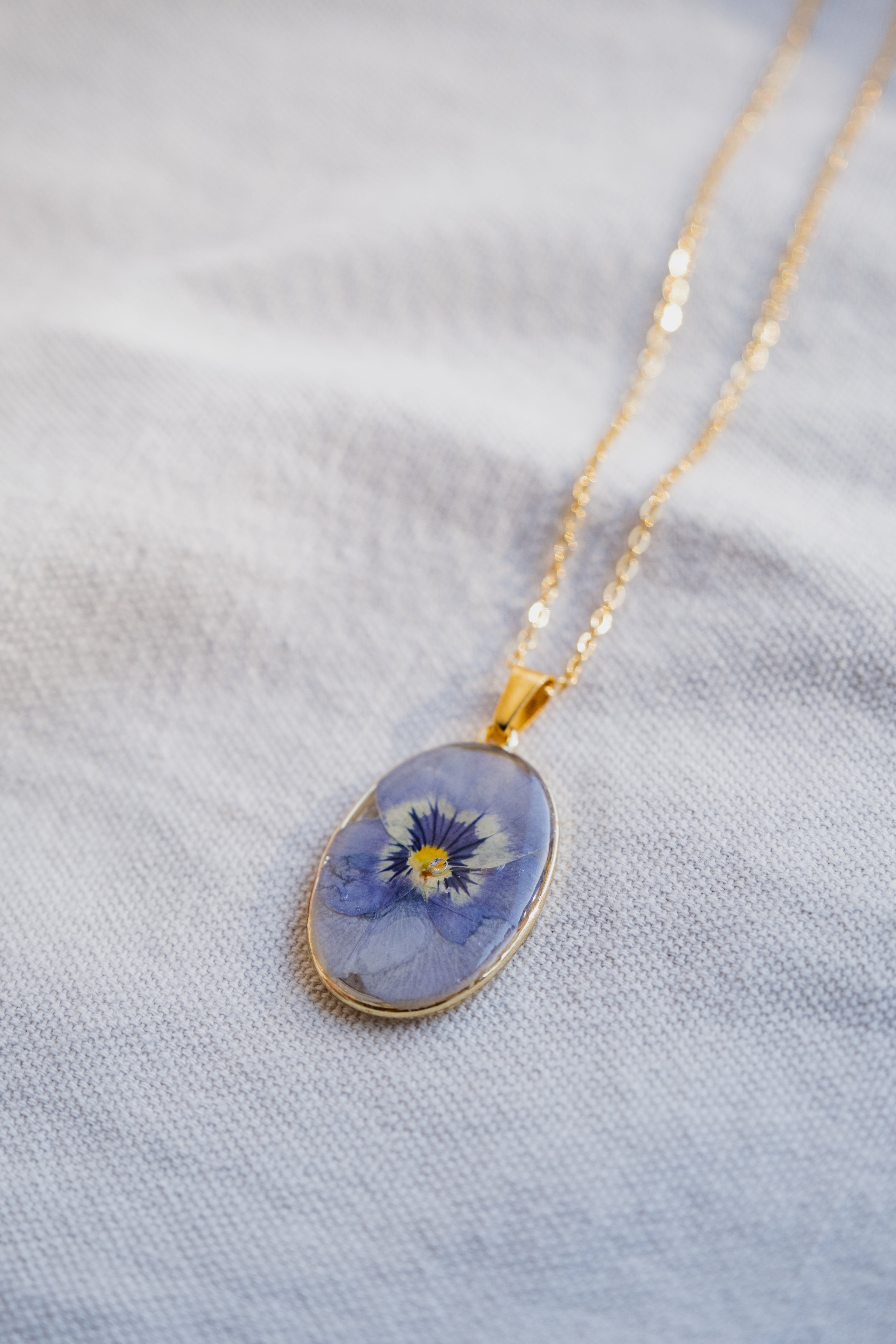 Collana ovale con viola del pensiero azzurra