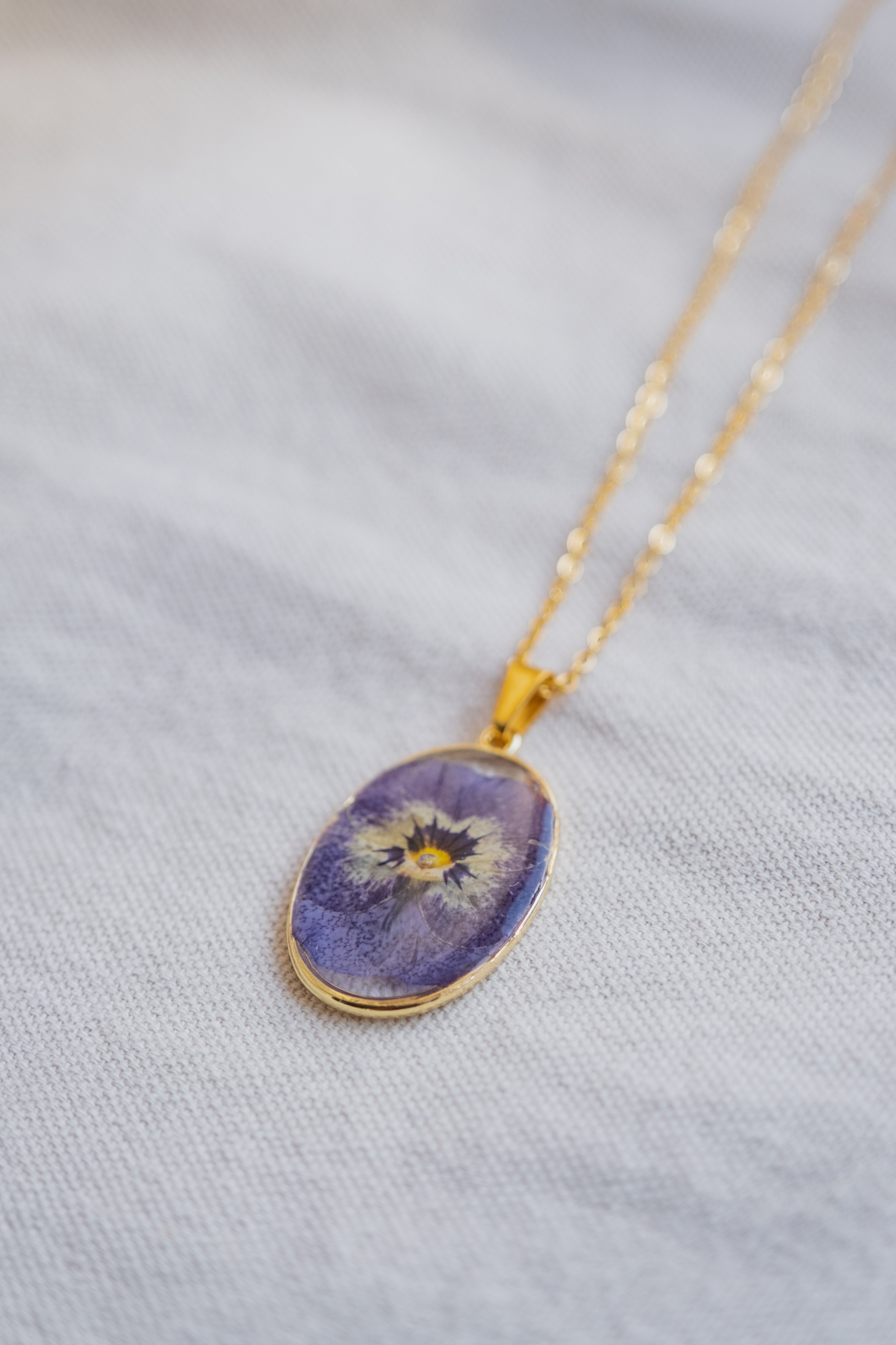 Collana ovale con viola del pensiero blu