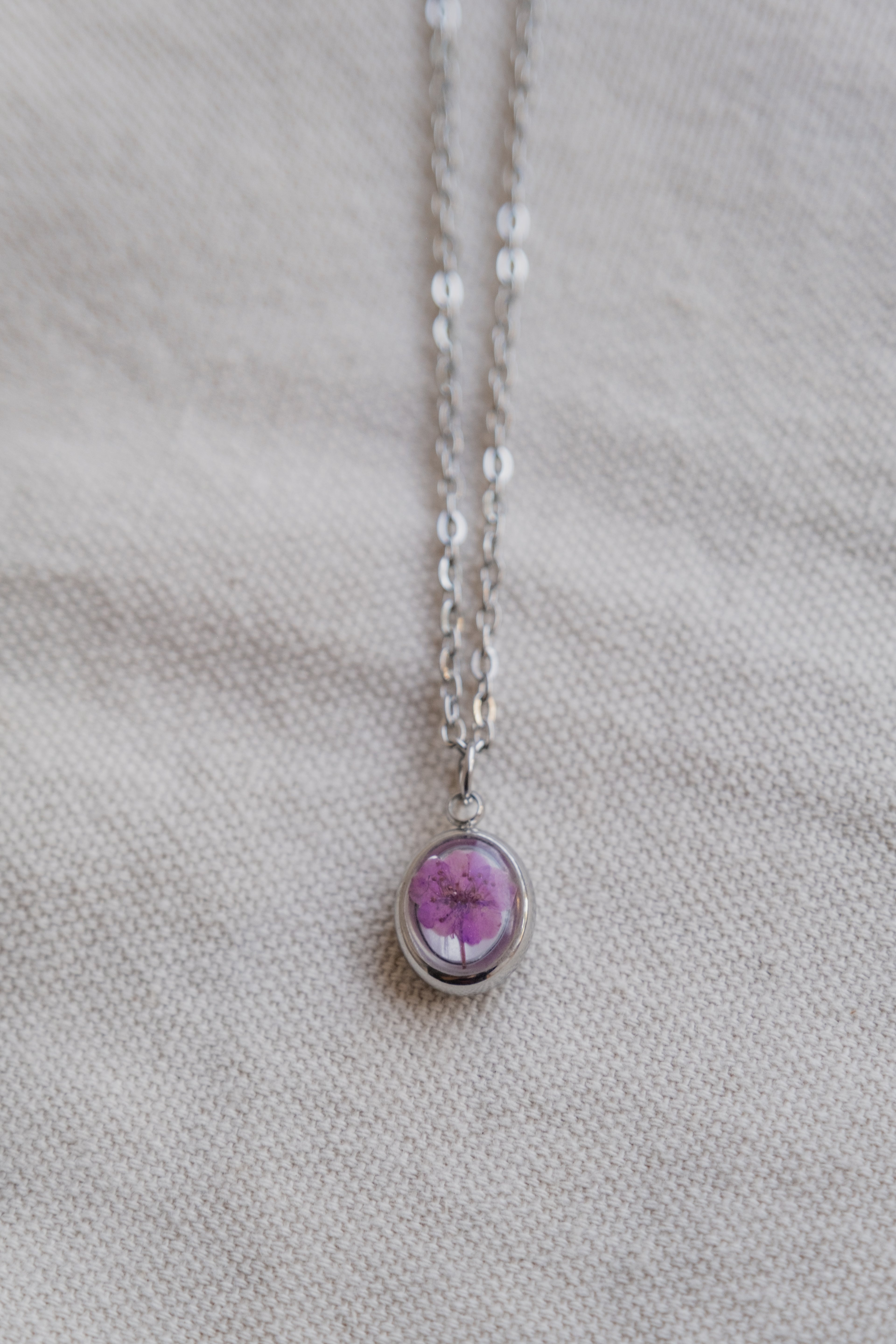 Collana ovetto con fondo in madreperla e narciso viola