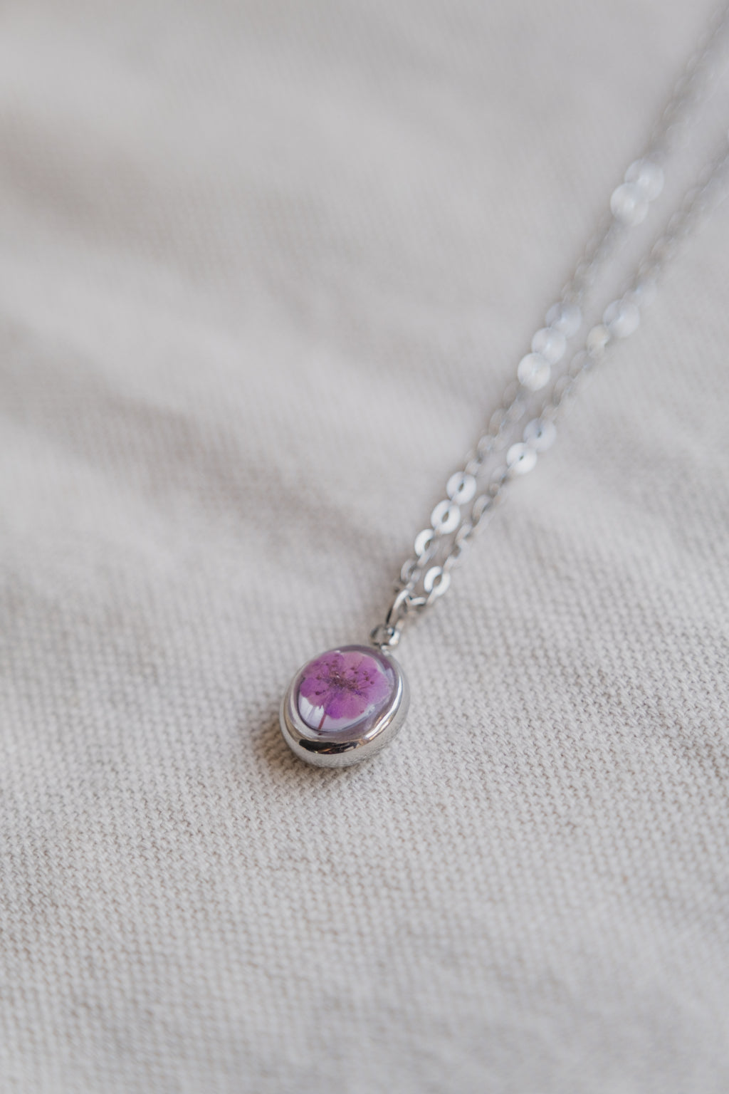 Collana ovetto con fondo in madreperla e narciso viola