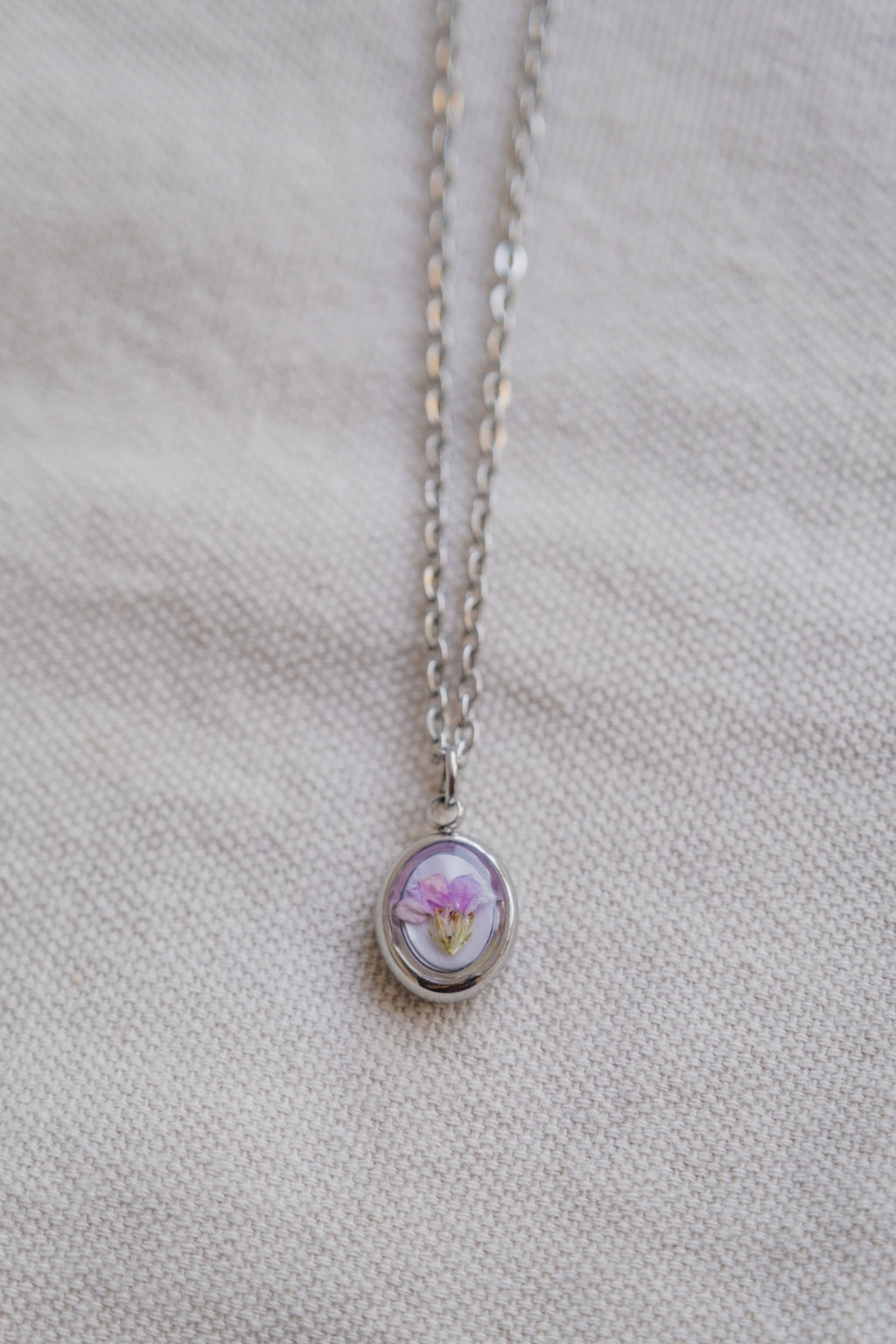 Collana ovetto con fondo in madreperla e fiore di campo
