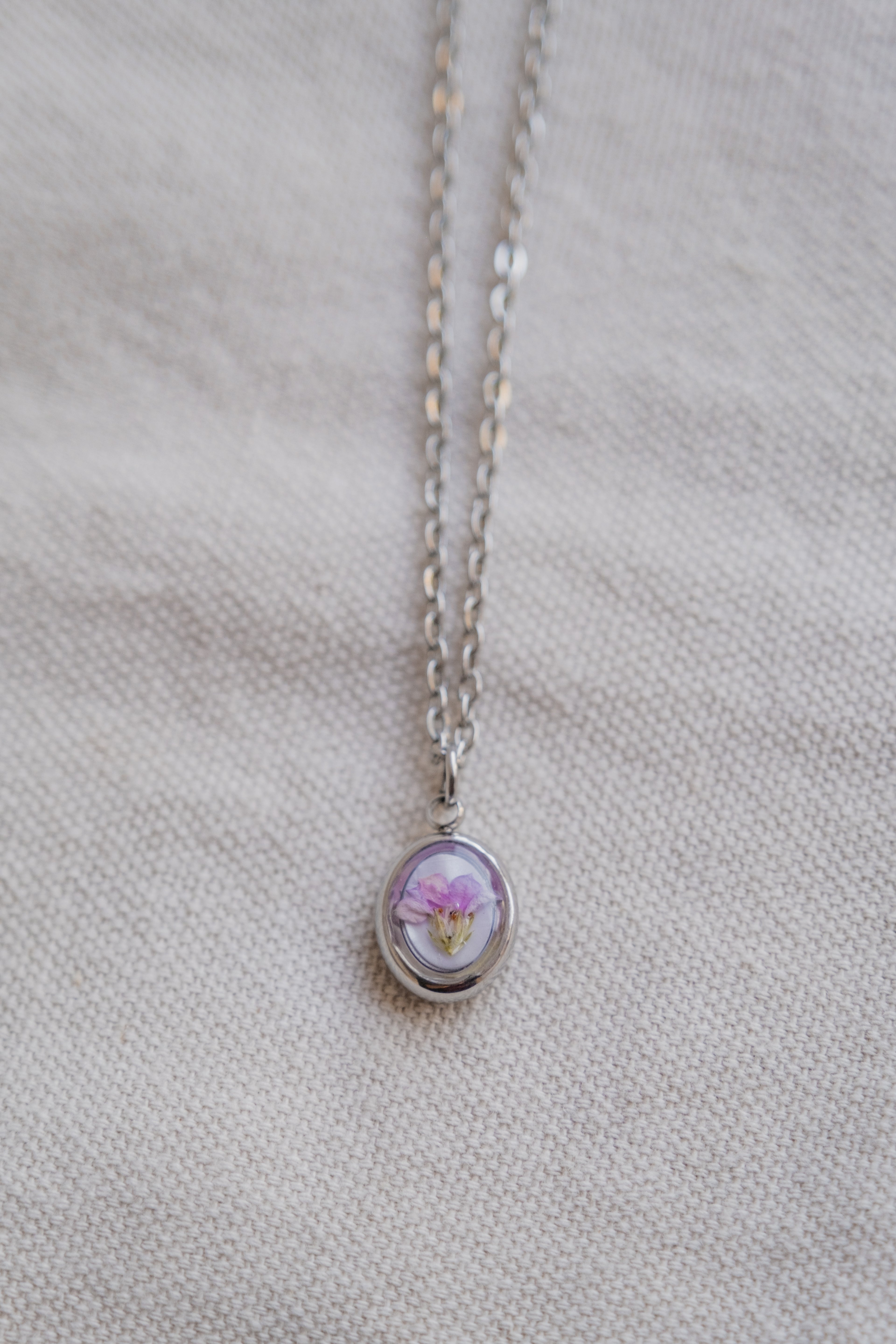 Collana ovetto con fondo in madreperla e fiore di campo