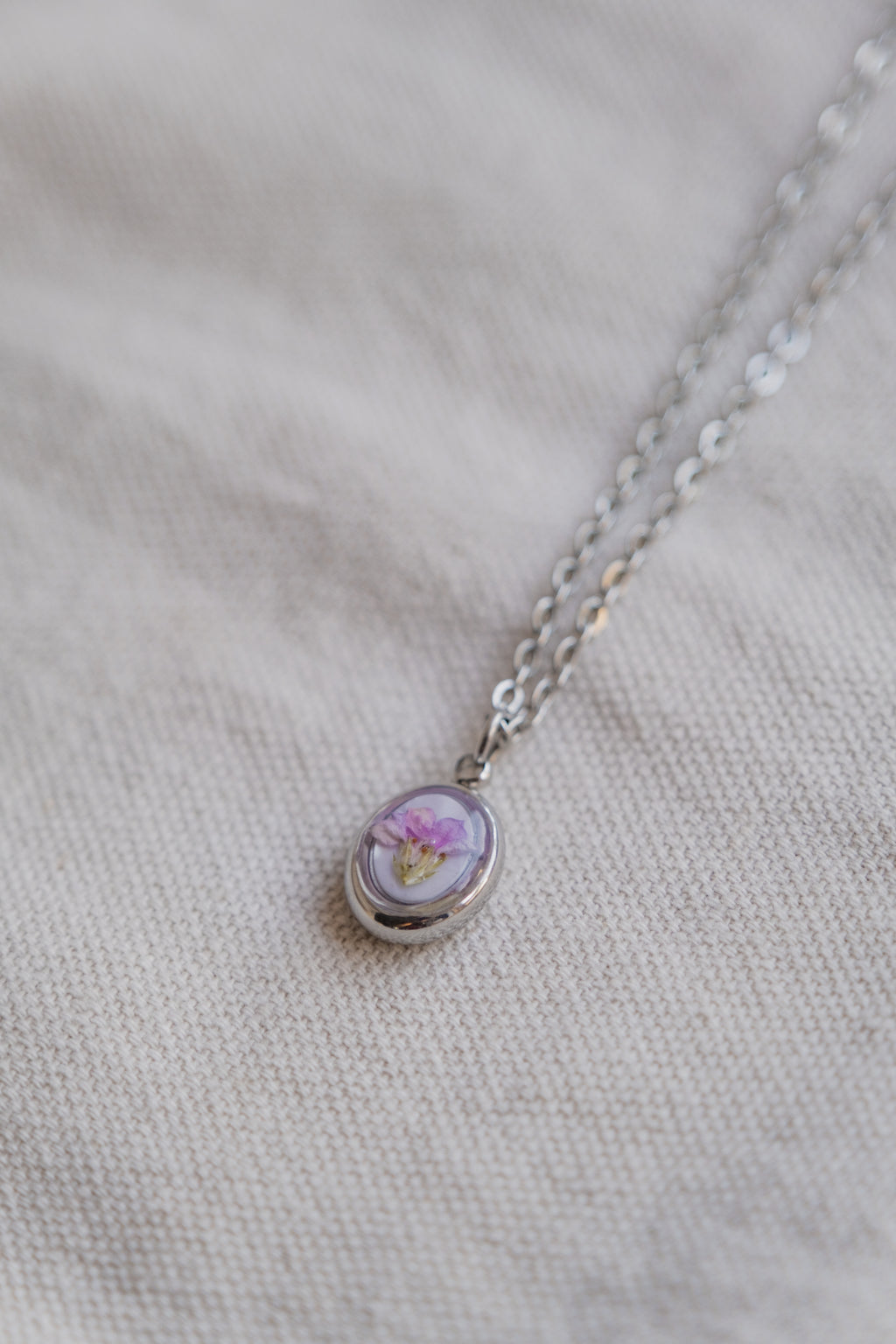 Collana ovetto con fondo in madreperla e fiore di campo
