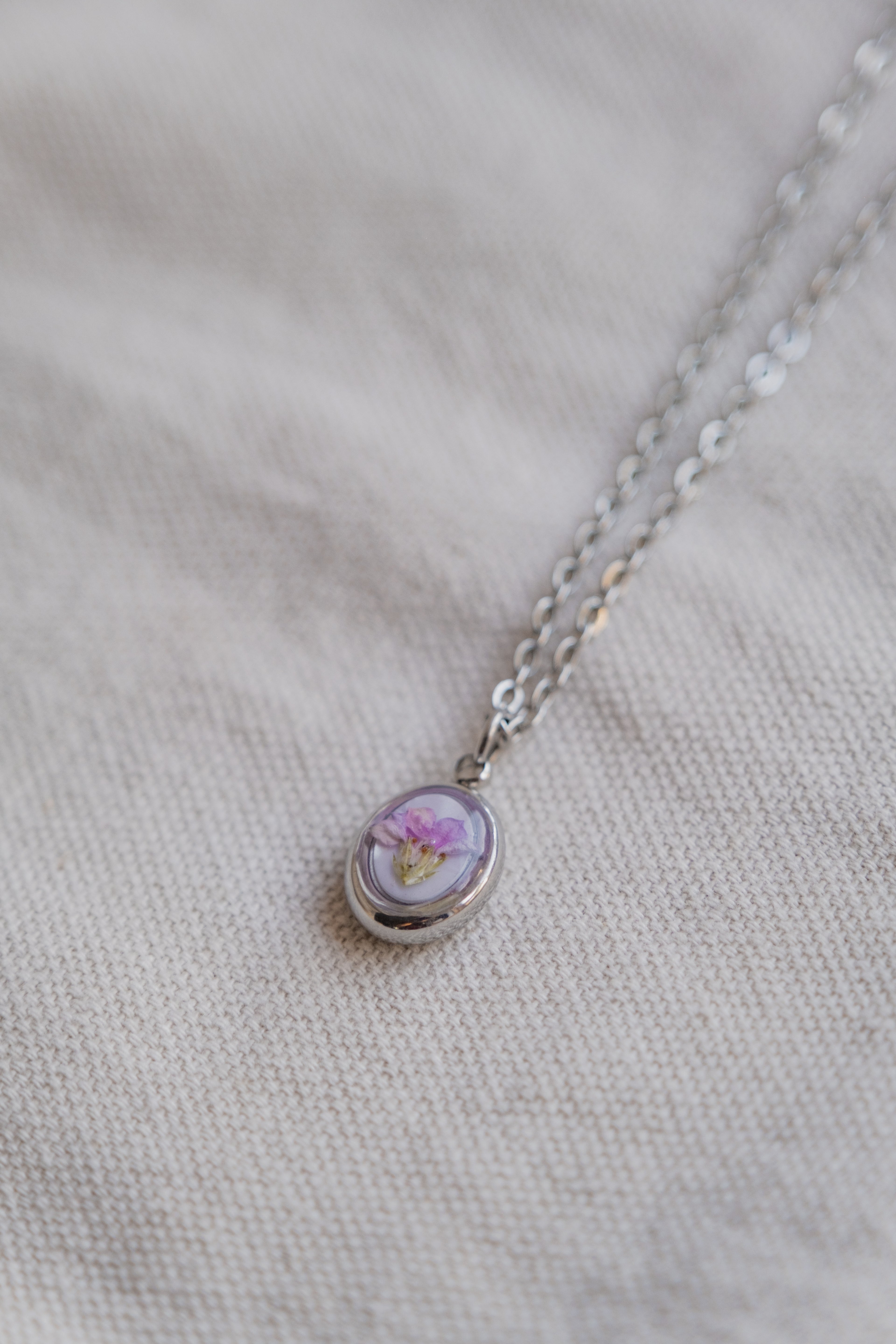 Collana ovetto con fondo in madreperla e fiore di campo