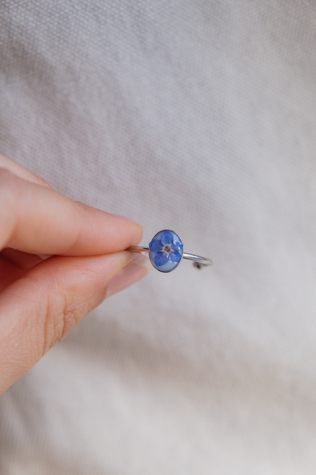 Anello con fondo bianco e "non ti scordar di me"