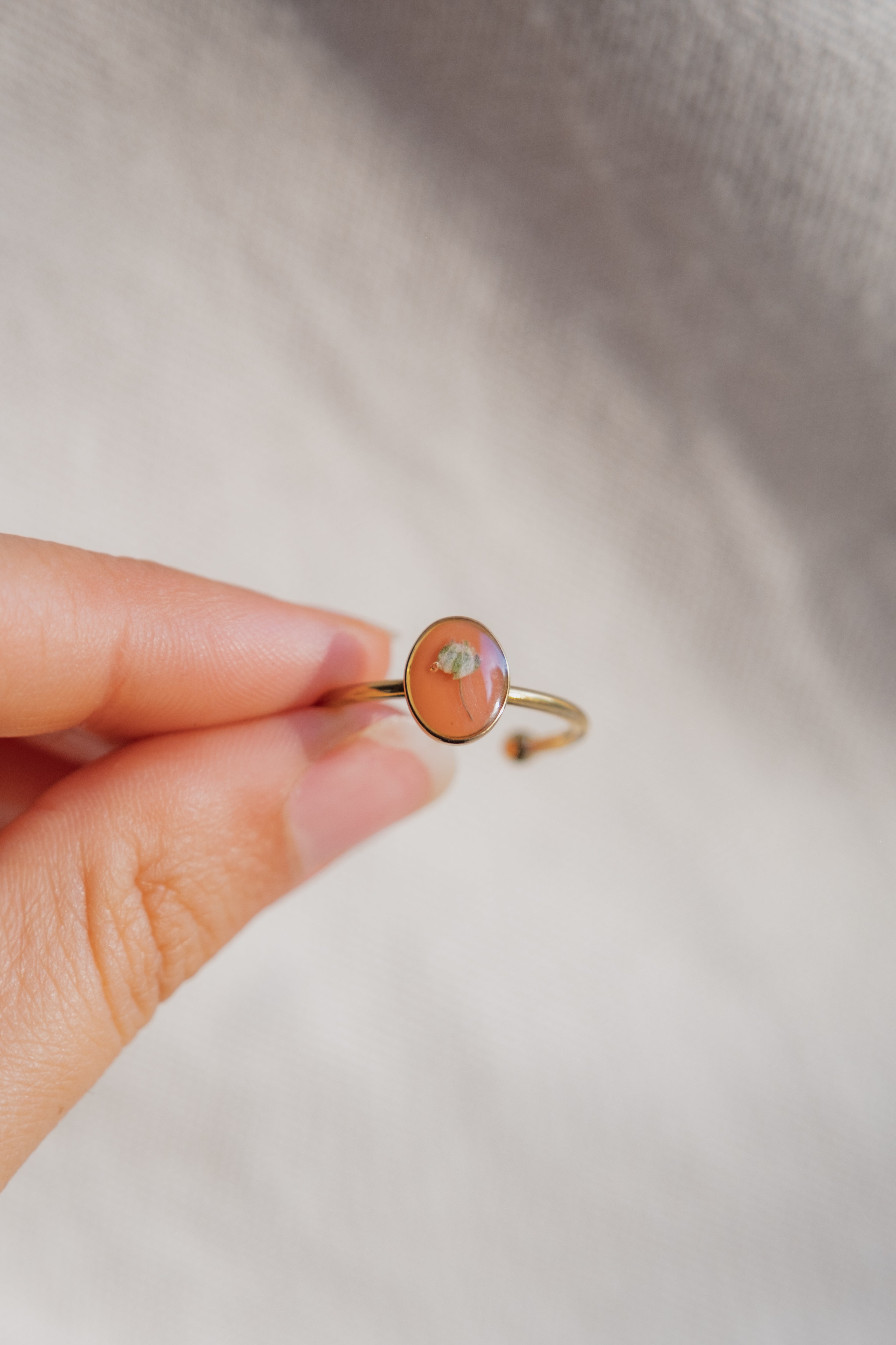 Anello con fondo arancione e fiore di Gypsophila bianca
