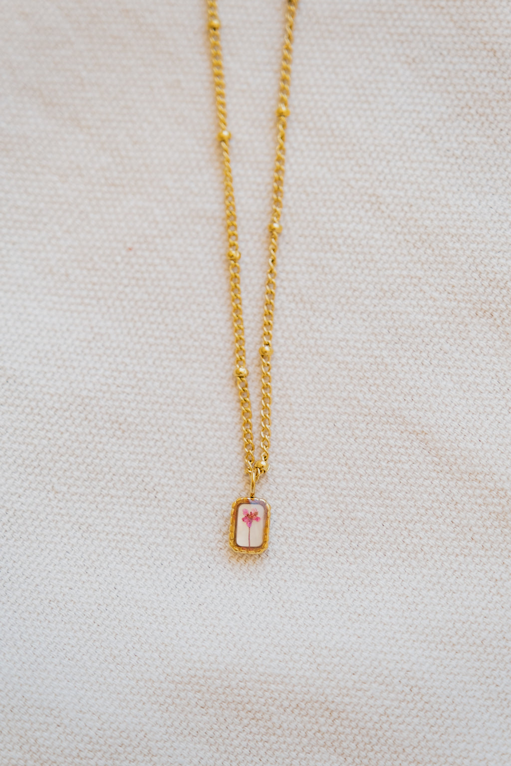 Collana mini con fondo in madreperla e fiore di carota selvatica rosa