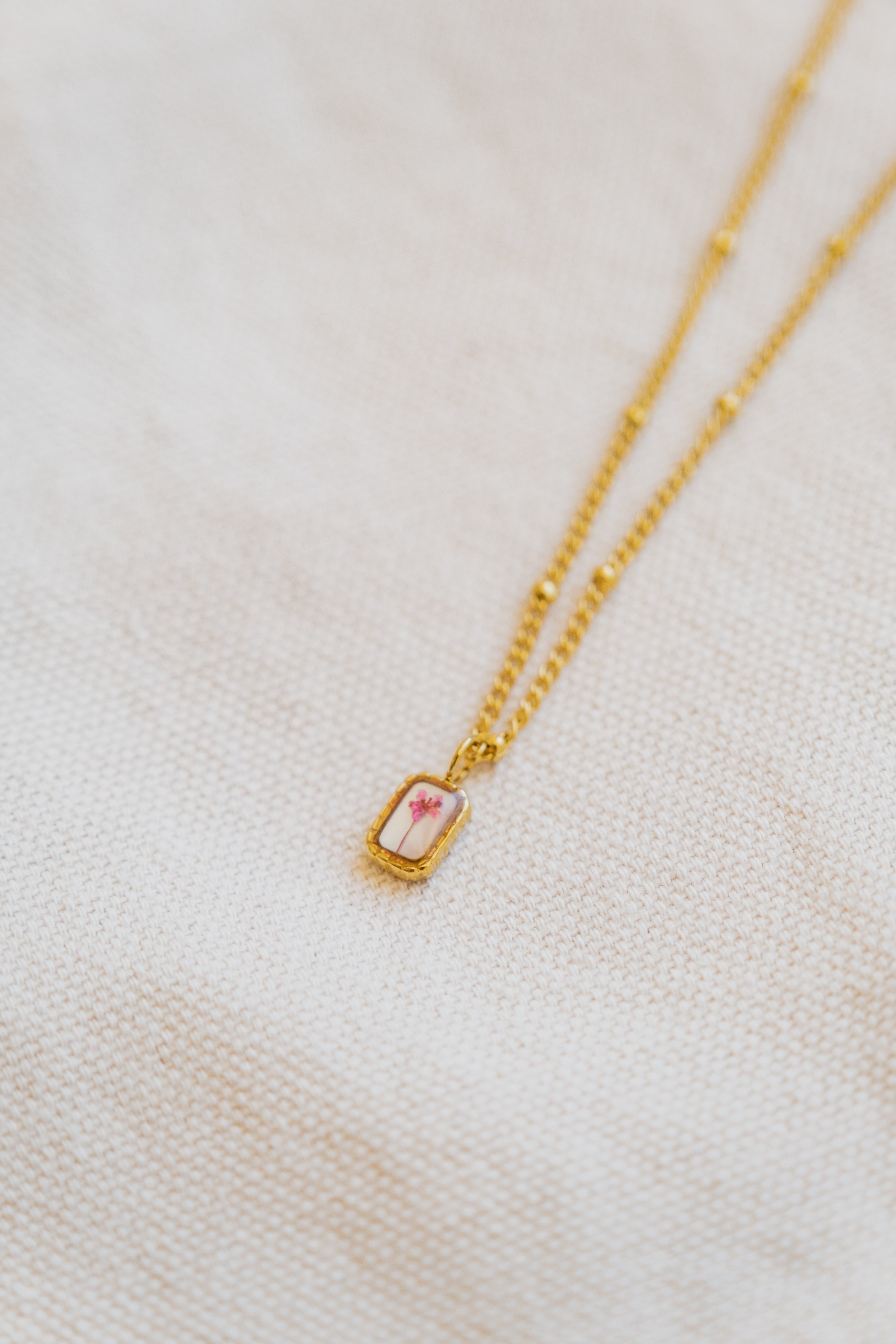 Collana mini con fondo in madreperla e fiore di carota selvatica rosa
