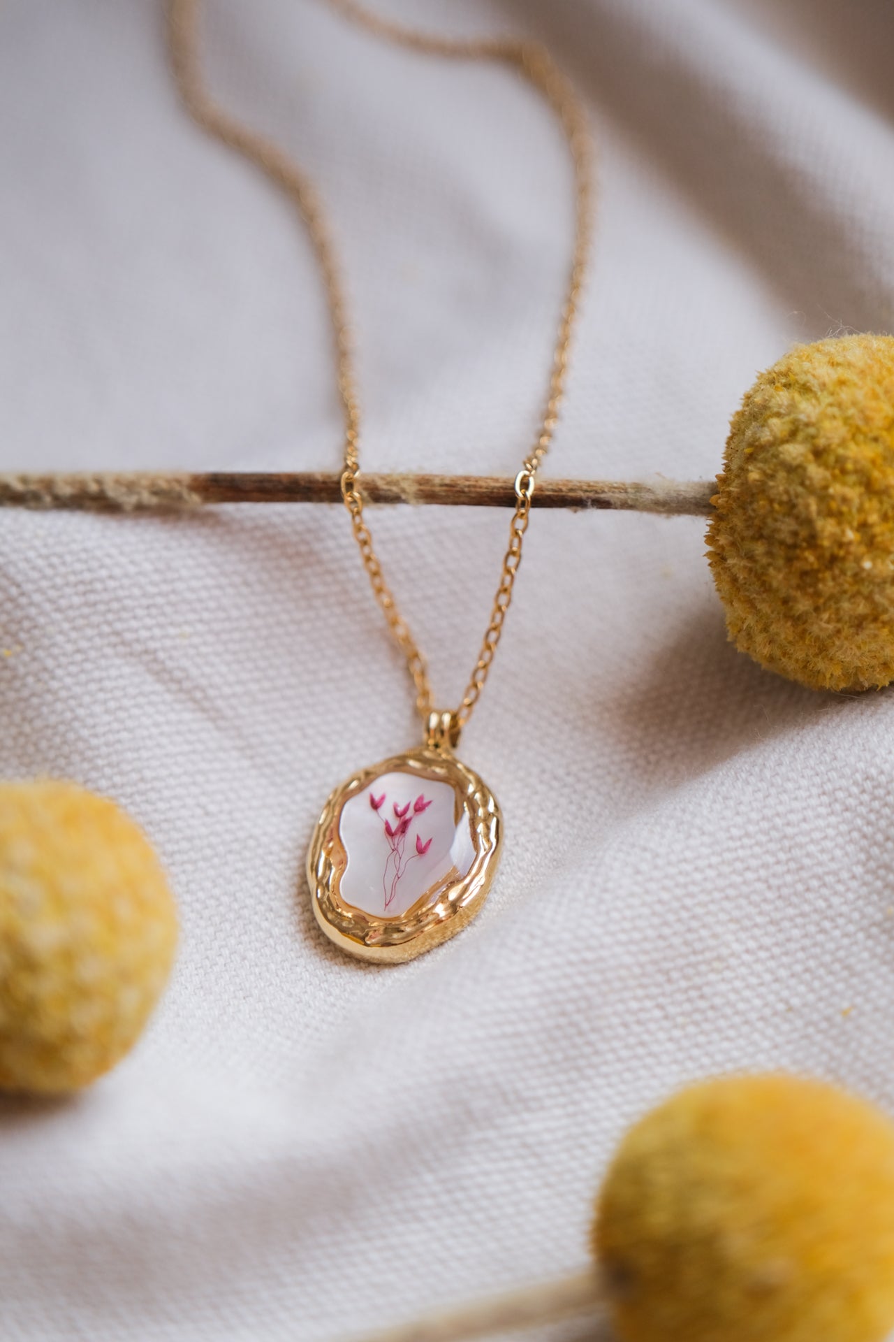 Collana ciondolo irregolare con fondo in madreperla e fiorellini rosa