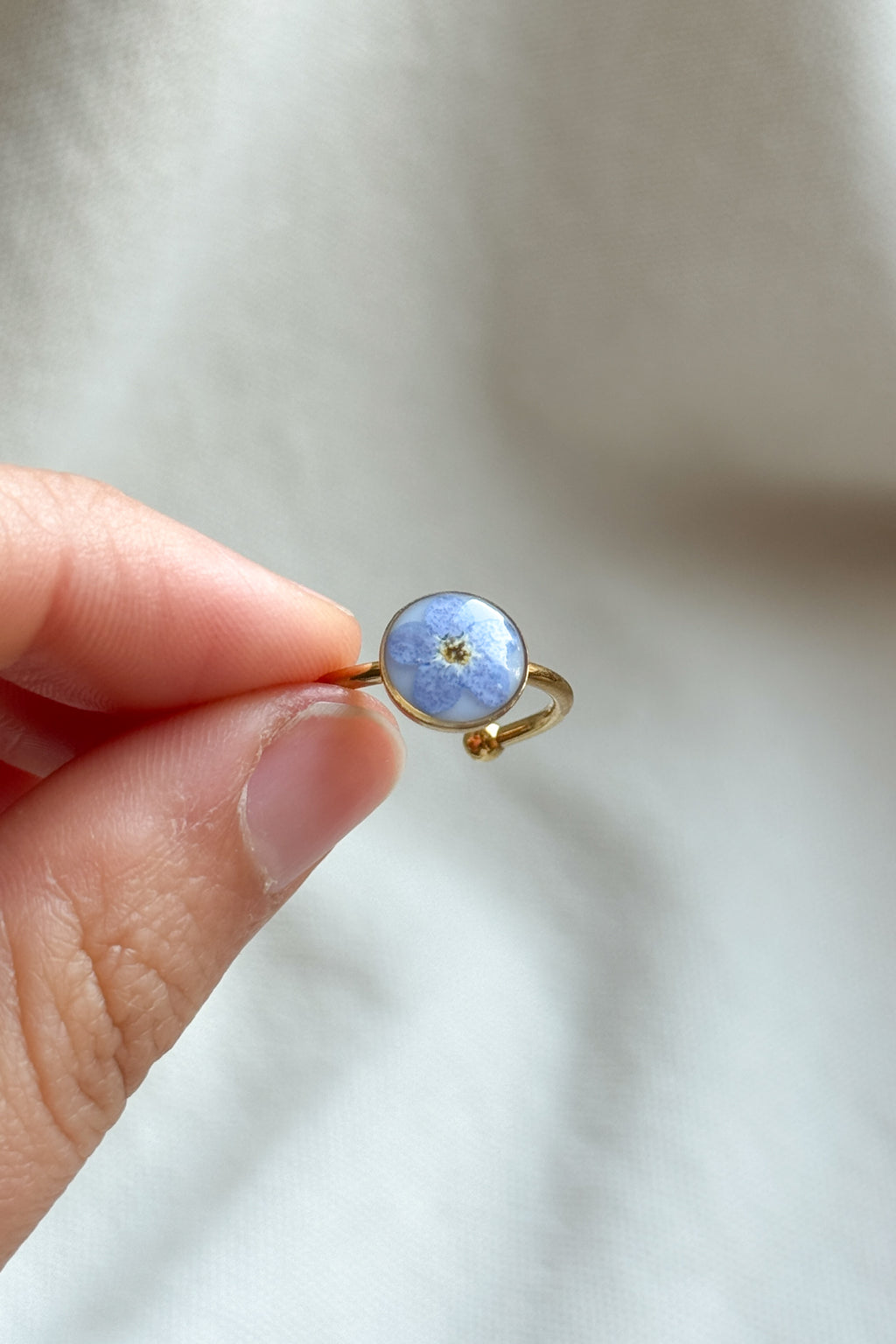 Anello con fondo bianco e "non ti scordar di me"