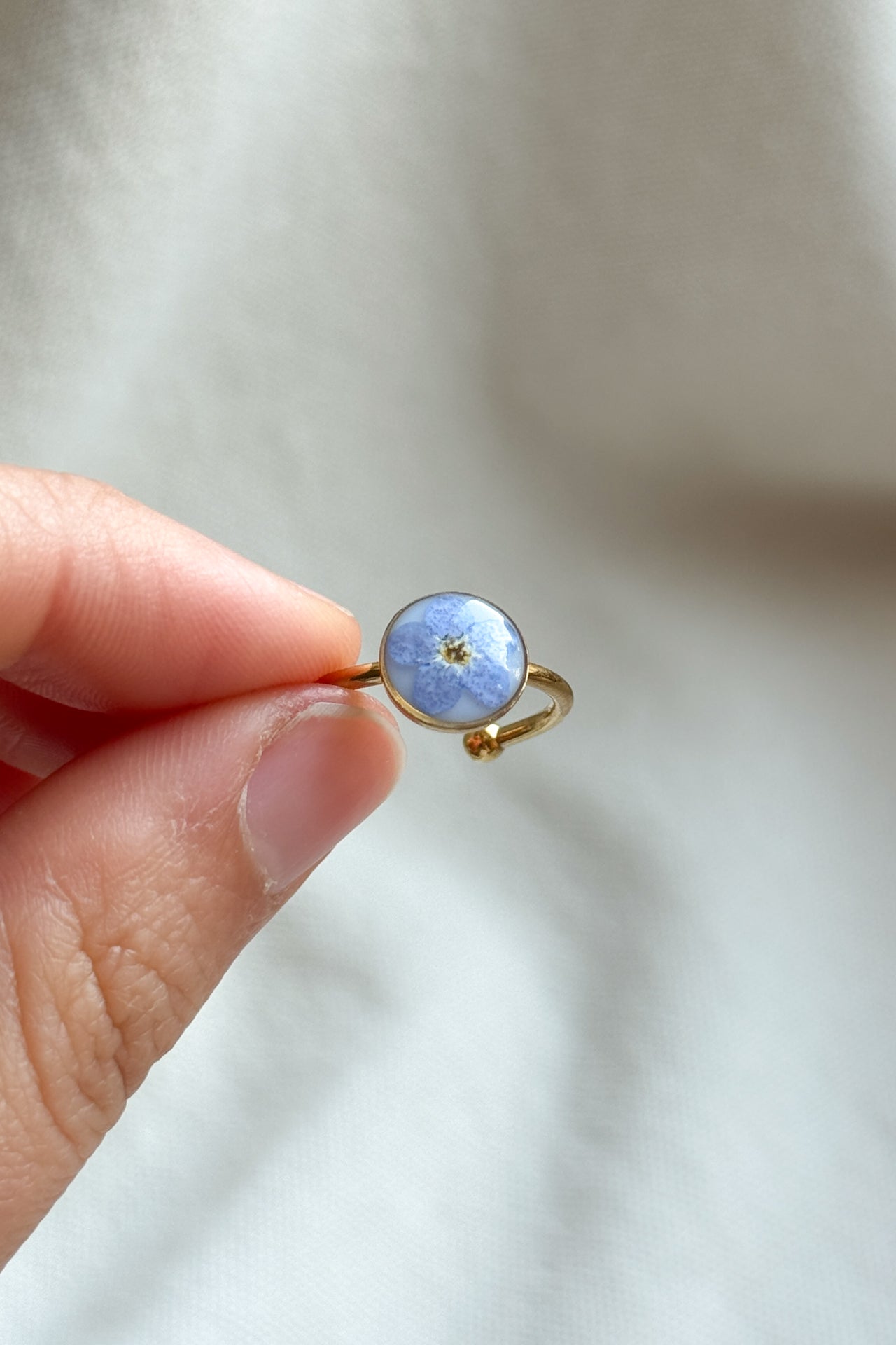 Anello con fondo bianco e "non ti scordar di me"