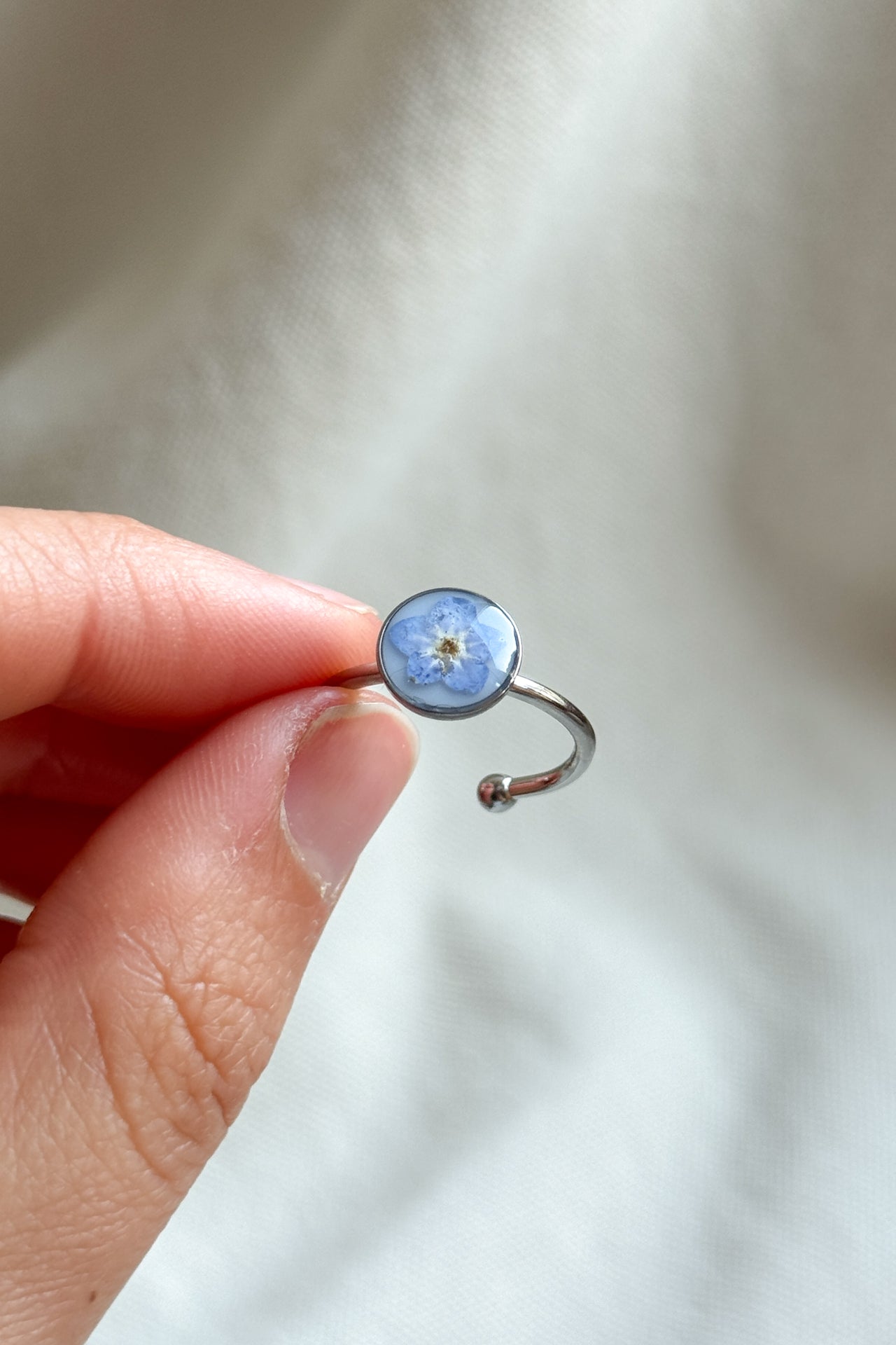 Anello con fondo bianco e "non ti scordar di me"