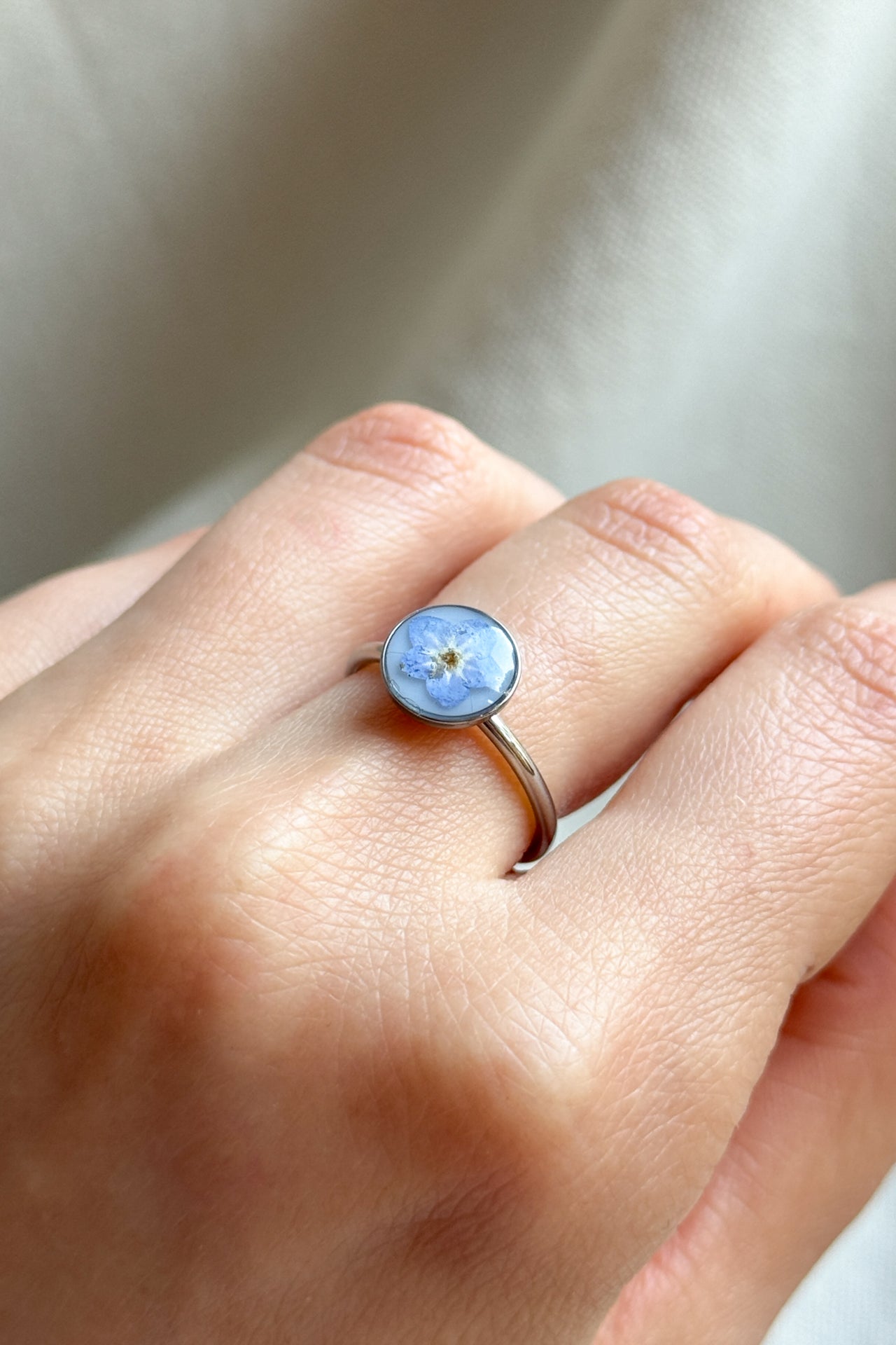 Anello con fondo bianco e "non ti scordar di me"
