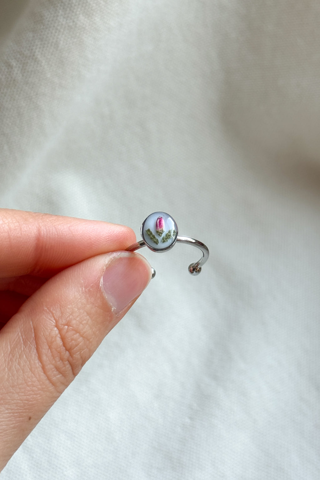 Anello con fondo bianco e fiori di erica
