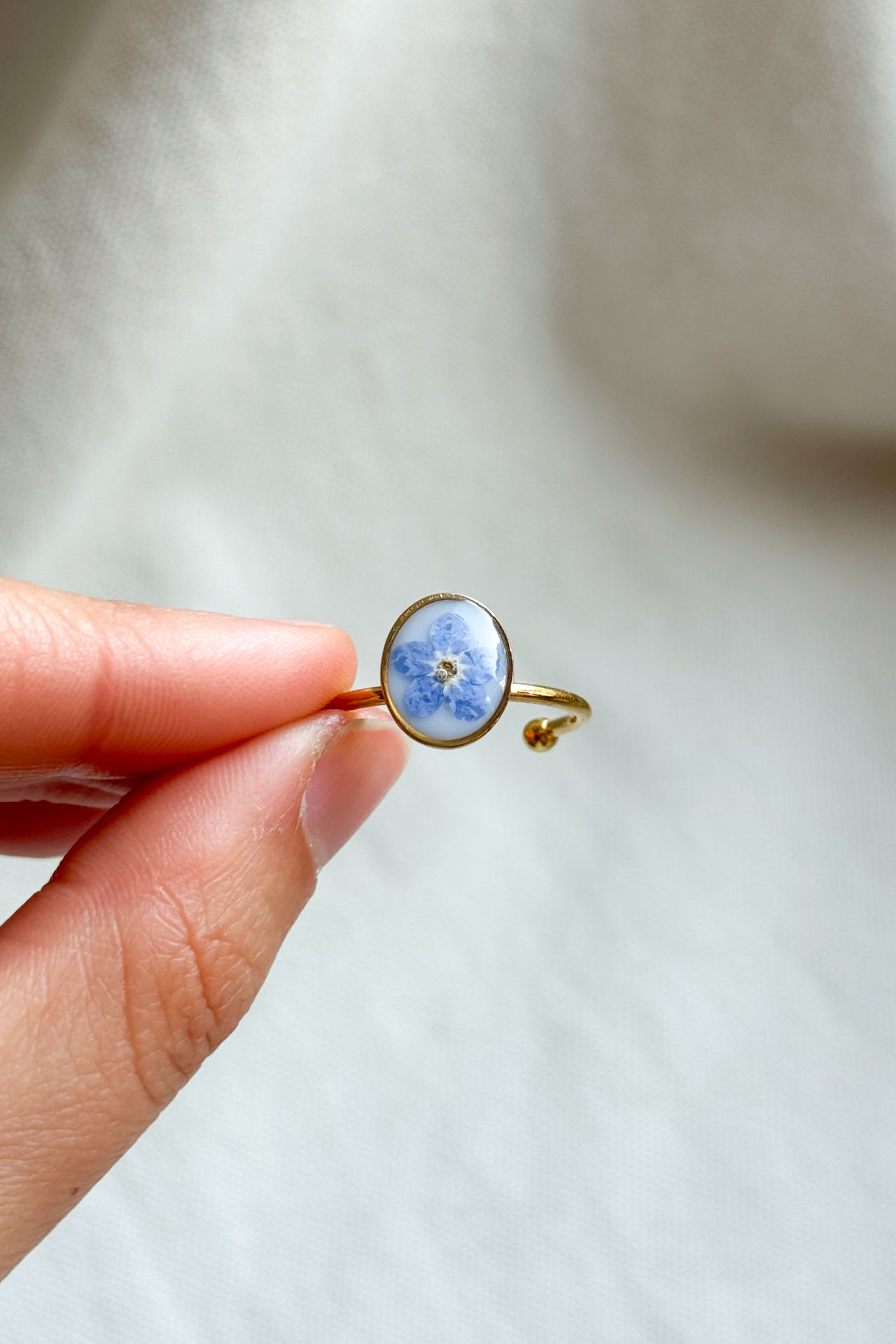 Anello con fondo bianco e "non ti scordar di me"