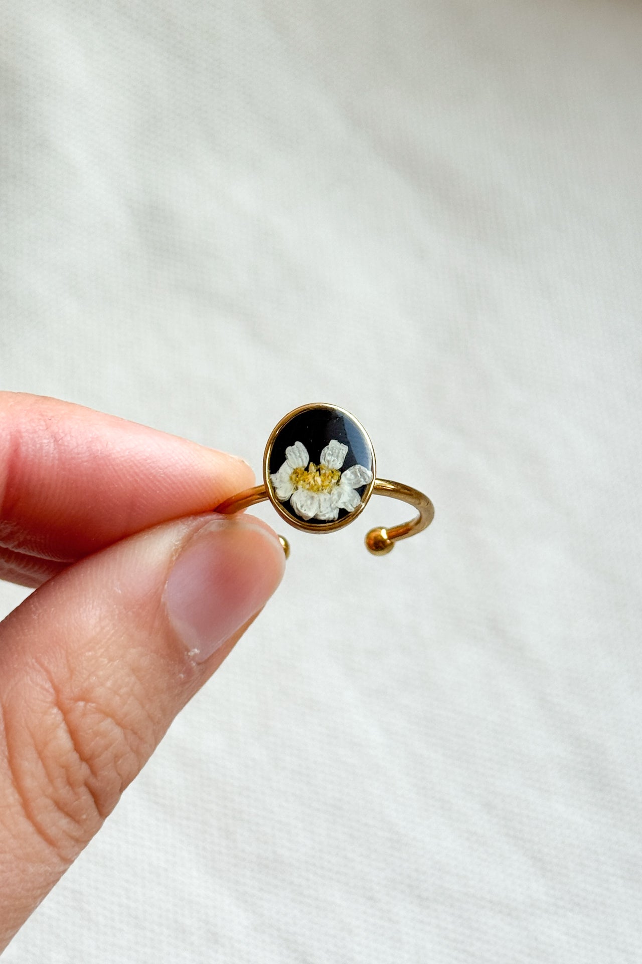 Anello con fondo nero e margherita
