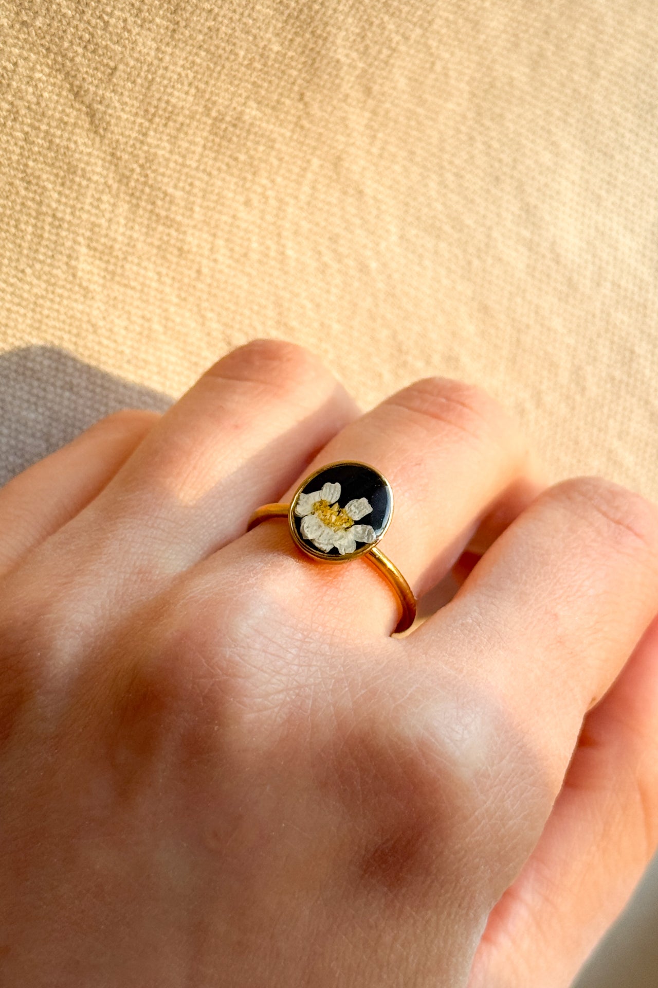 Anello con fondo nero e margherita