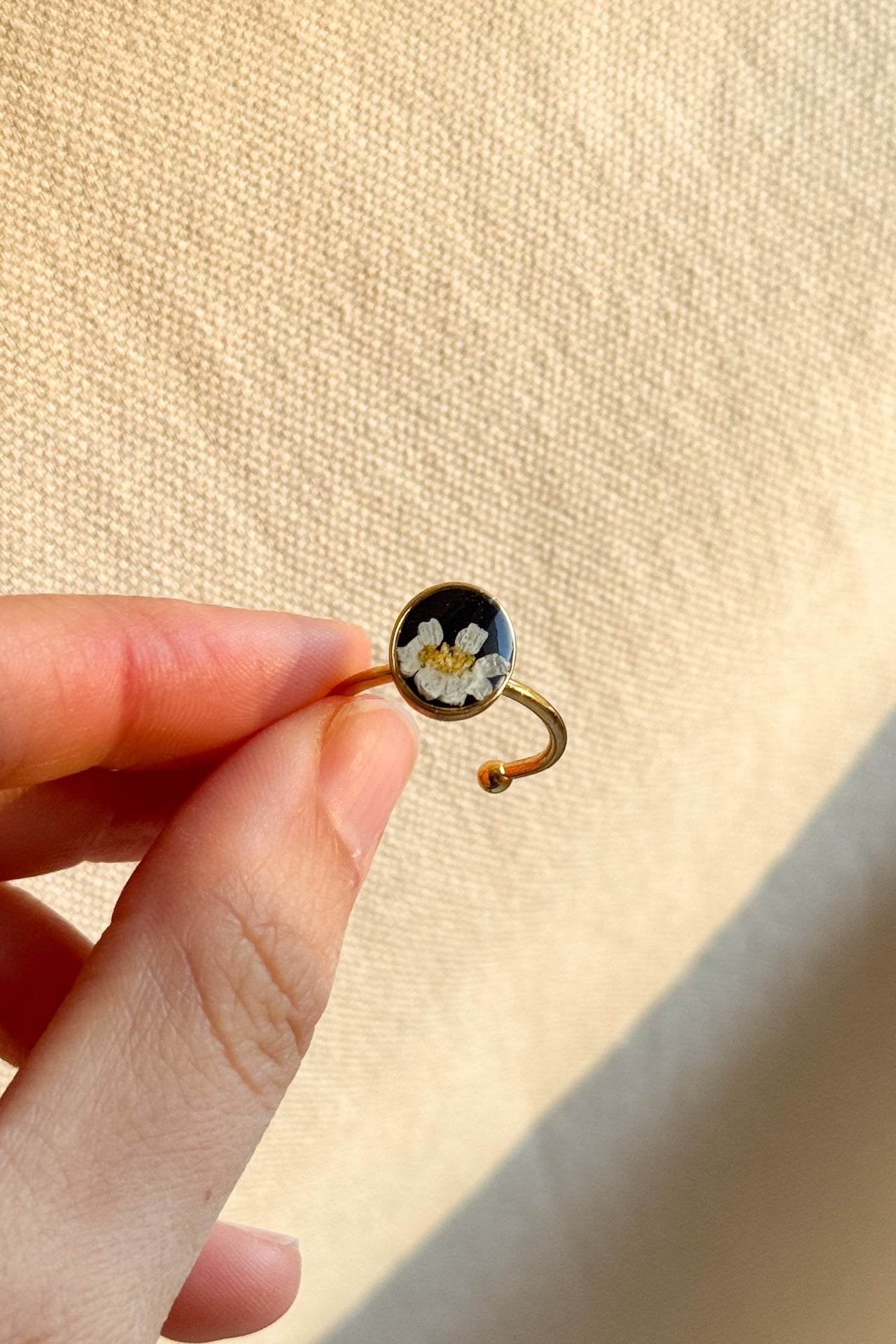Anello con fondo nero e margherita