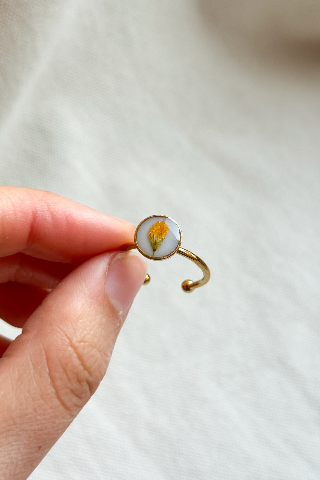 Anello con fondo bianco e fiori di campo gialli