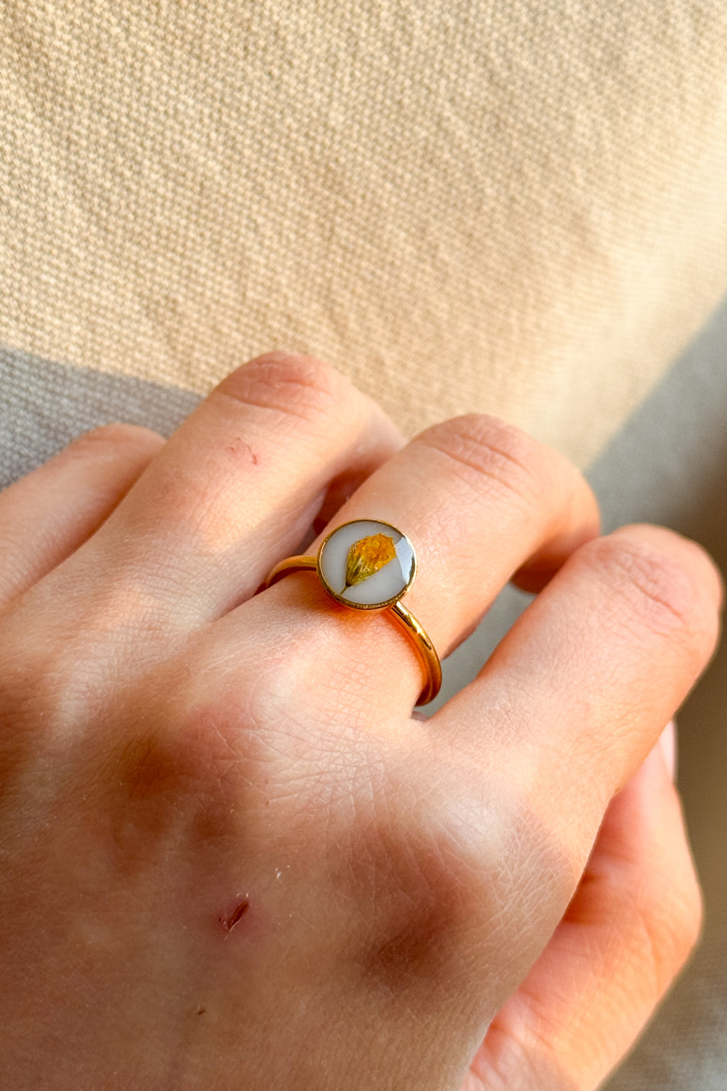 Anello con fondo bianco e fiori di campo gialli
