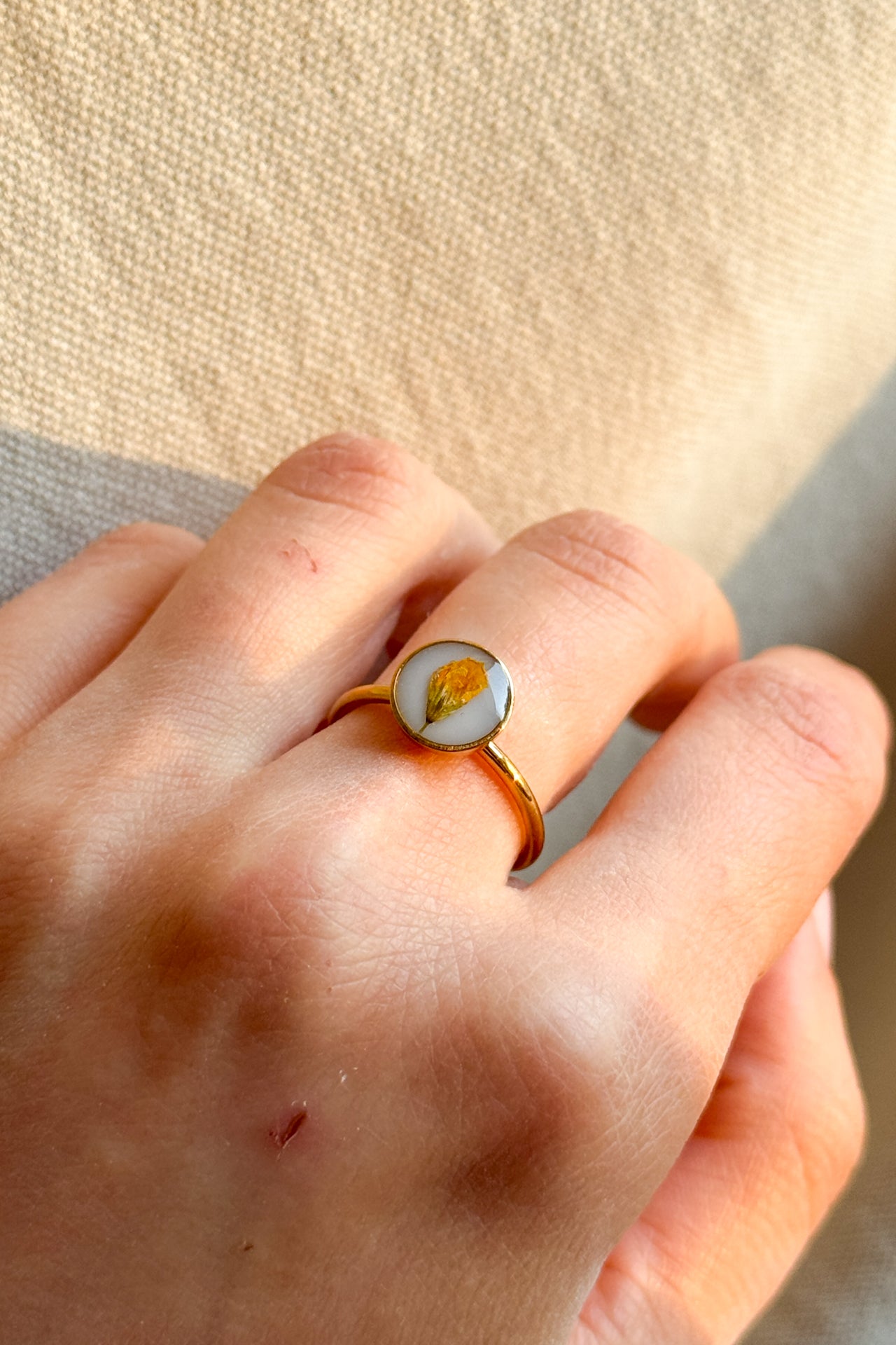 Anello con fondo bianco e fiori di campo gialli