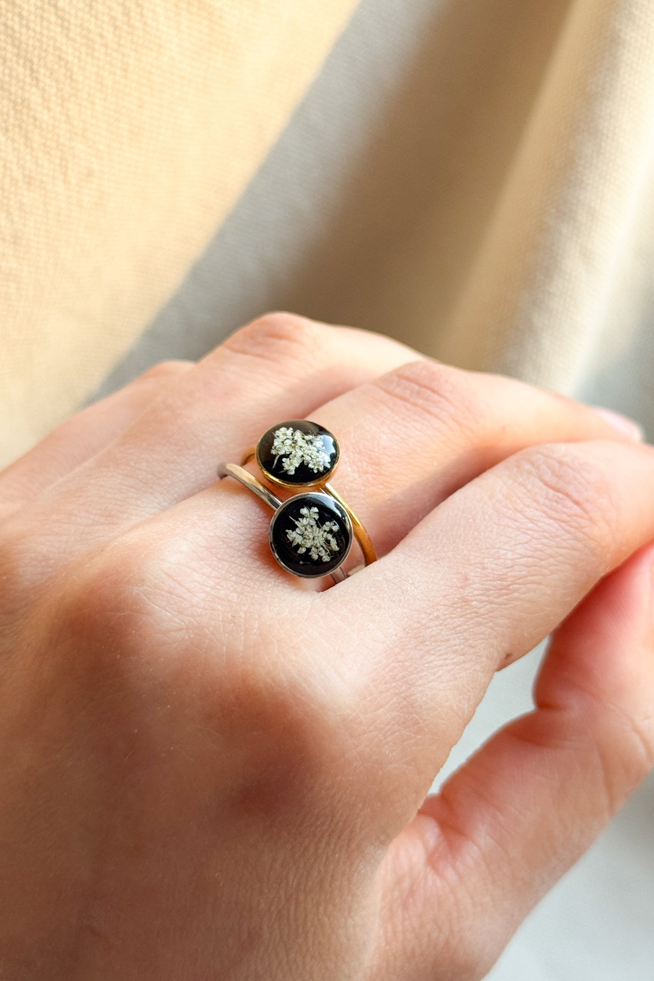 Anello con fondo nero e fiori di carota selvatica