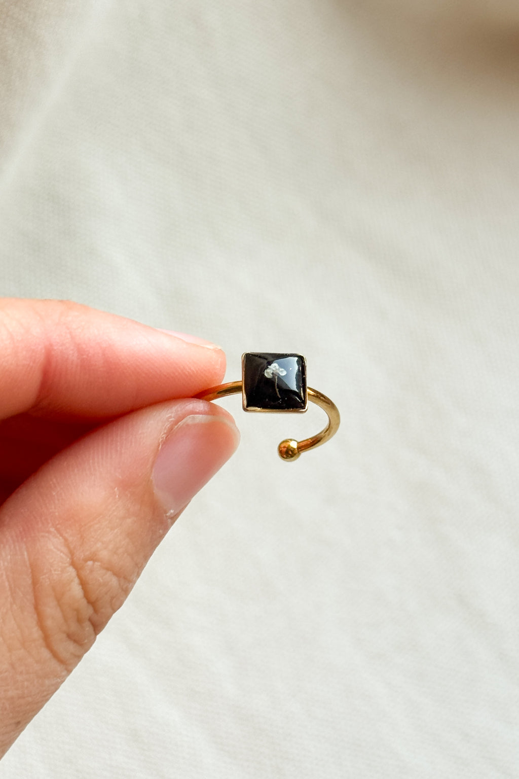 Anello con fondo nero e fiorellino di carota selvatica