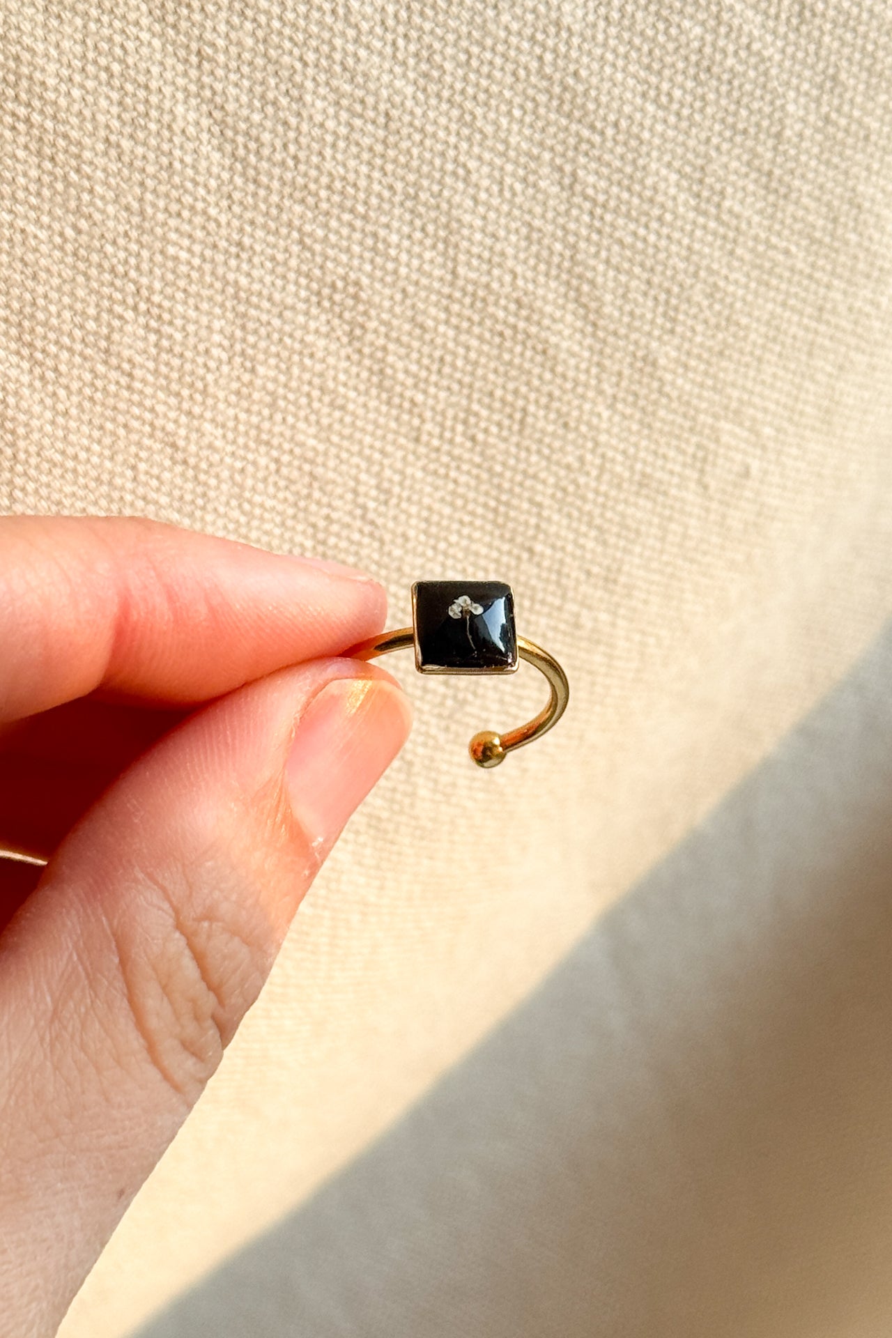Anello con fondo nero e fiorellino di carota selvatica