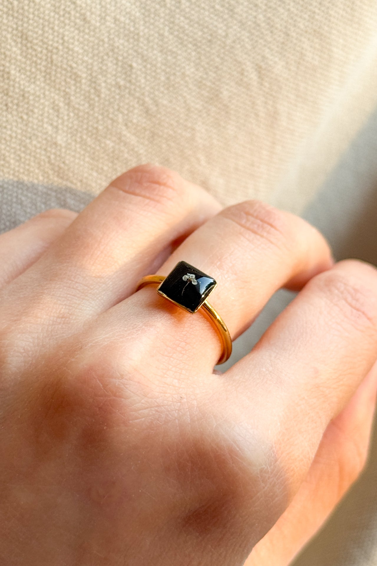 Anello con fondo nero e fiorellino di carota selvatica