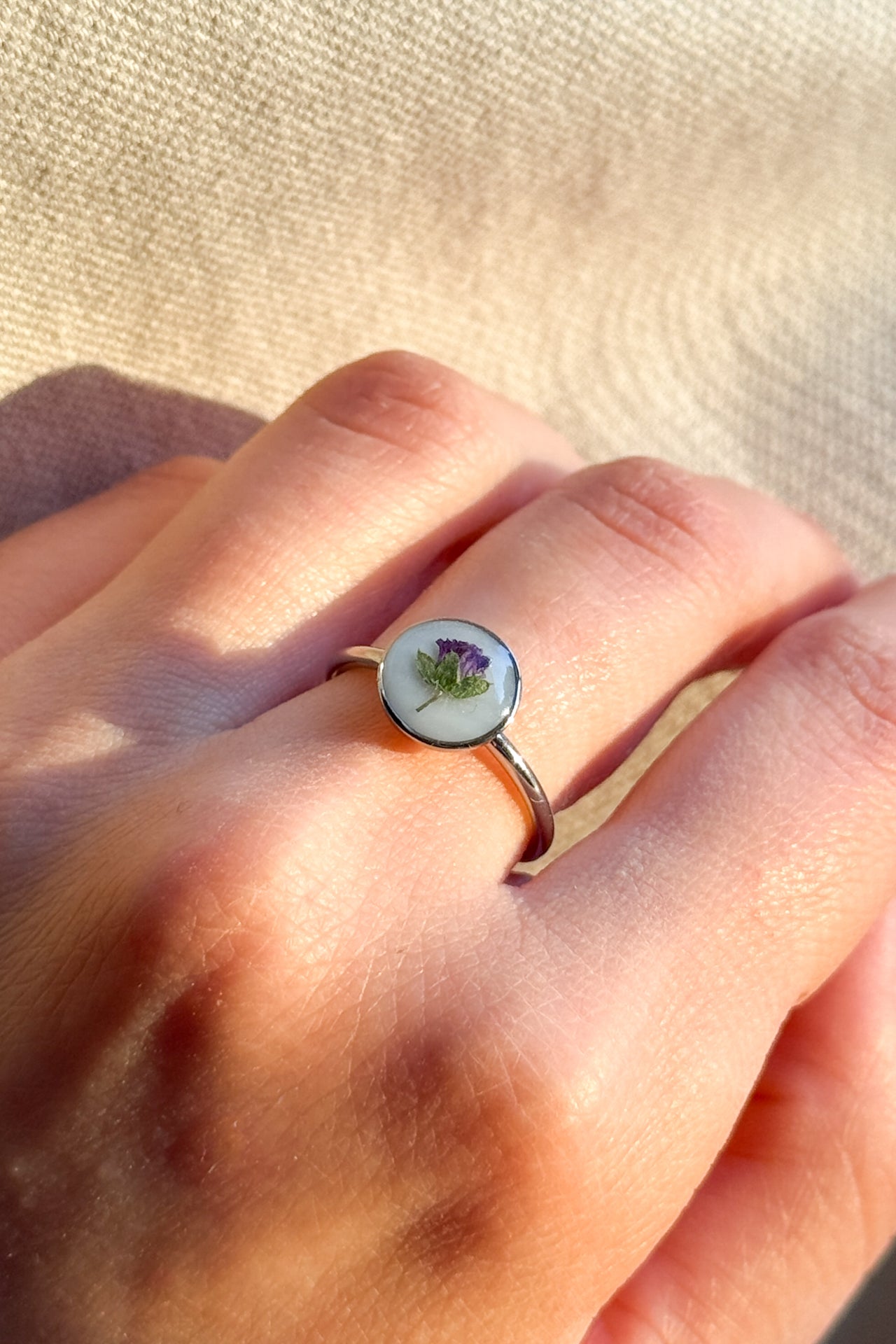 Anello con fondo bianco e violetta di campo