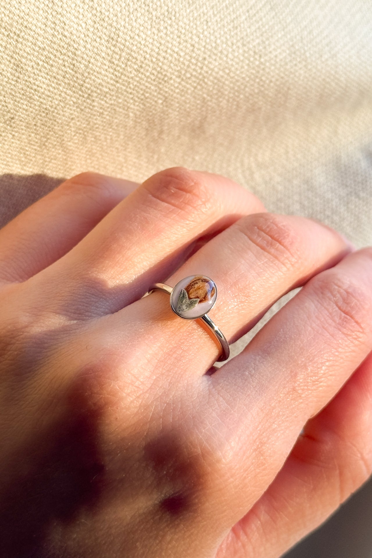 Anello con fondo rosa e fiore di rosmarino